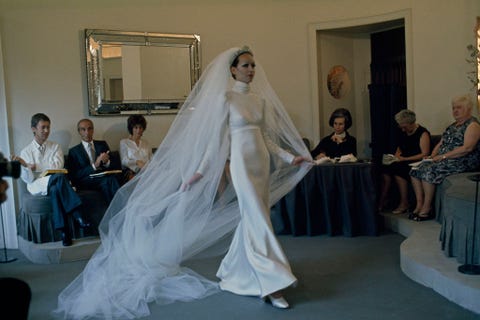 Een model draagt een op maat gemaakte bruidsjurk op een Parijse modeshow in de vroege jaren 70