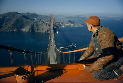 Een arbeiderverftde Golden Gate Bridge in San Francisco met een frisse nieuwe laag vande iconische oranje kleur De kleurwerdgekozen omte helpende brug zichtbaar te houden in de beroemde mist van de stad