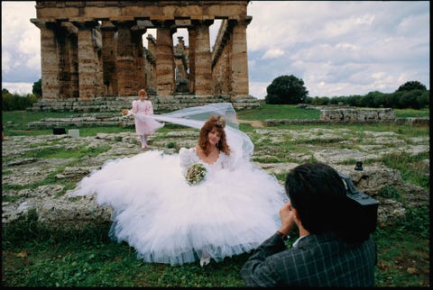 Een bruid poseert voor de Tweede Tempel van Hera in Paestum Itali De tempel dateert uit de vijfde eeuw voor Christus en eert de Griekse godin van het huwelijk het gezin en de geboorte