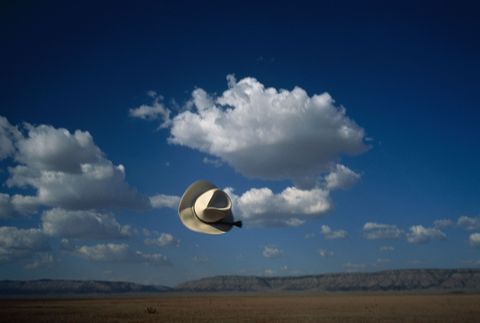 Door een windvlaag waait een cowboyhoed over de Route 66 in Arizona
