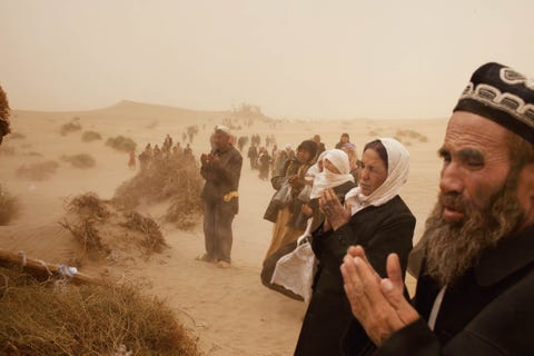 Uygurpelgrims bidden bij de graven van islamitische heiligen tijdens het Imam Asimfestival in de buurt van Hotan provincie Xinjiang China Het Oeigoerse volk is een moslimminderheid in China en wordt zwaar vervolgd door de Chinese regering