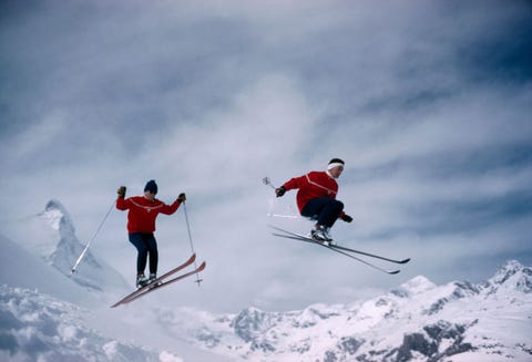 Skiers take flight in Zermatt Switzerland as the iconic Matterhorn looms in the background