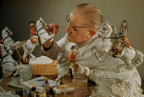 Een kunstenaar werkt de verf op een porseleinen beeldje bij voordat het opnieuw wordt verhit in een fabriek in Wenen Oostenrijk Deze foto verscheen oorspronkelijk in de National Geographic editie van juni 1951 in een artikel genaamd Austria Outpost of Democracy
