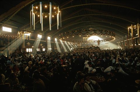Op deze foto uit de editie van maart 1974 komen er massas mensen naar tavernes in Mnchen Duitsland om het Oktoberfest te vieren Bier eten en muziek trekken elk jaar miljoenen mensen van over de hele wereld naar het festival