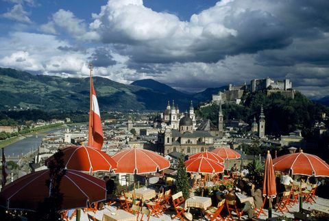 In Salzburg Oostenrijk in de vroege jaren 50 kijken restaurants uit over de stad en de rivier de Salzach Rechtsboven torent Fort Hohensalzburg uit boven de rest van de stad