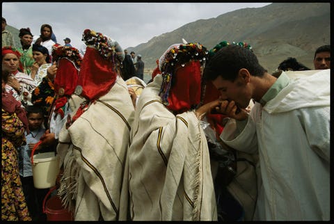 Een Berberbruidegom kust zijn bruid tijdens een massahuwelijk in Taarart Marokko Berbers die op het platteland van Marokko wonen zetten culturele tradities voort die minstens 5000 jaar hebben geduurd