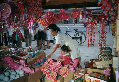 Een moeder koopt een pop voor haar dochter op een markt in Osaka Japan De foto verscheen in de mei 1950 editie van National Geographic in een verhaal dat ging over veranderingen in Japan na het einde van de Tweede Wereldoorlog 
