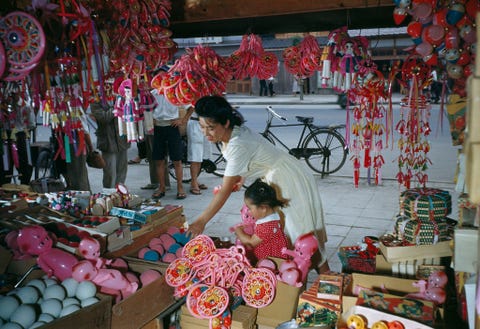 Een moeder koopt een pop voor haar dochter op een markt in Osaka Japan De foto verscheen in de mei 1950 editie van National Geographic in een verhaal dat ging over veranderingen in Japan na het einde van de Tweede Wereldoorlog