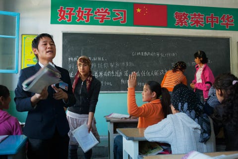 Een Hanleraar roept het juiste antwoord in het Chinees op een Oeigoerse middelbare school in Azak Xinjiang China Uit recent mediaonderzoek blijkt dat de Chinese regering zich op Oeigoeren een groep van moslimminderheden heeft gericht voor massale detenties en zelfs gedwongen geboortebeperking