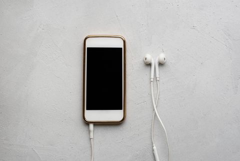 mobile phone and headphones on white background