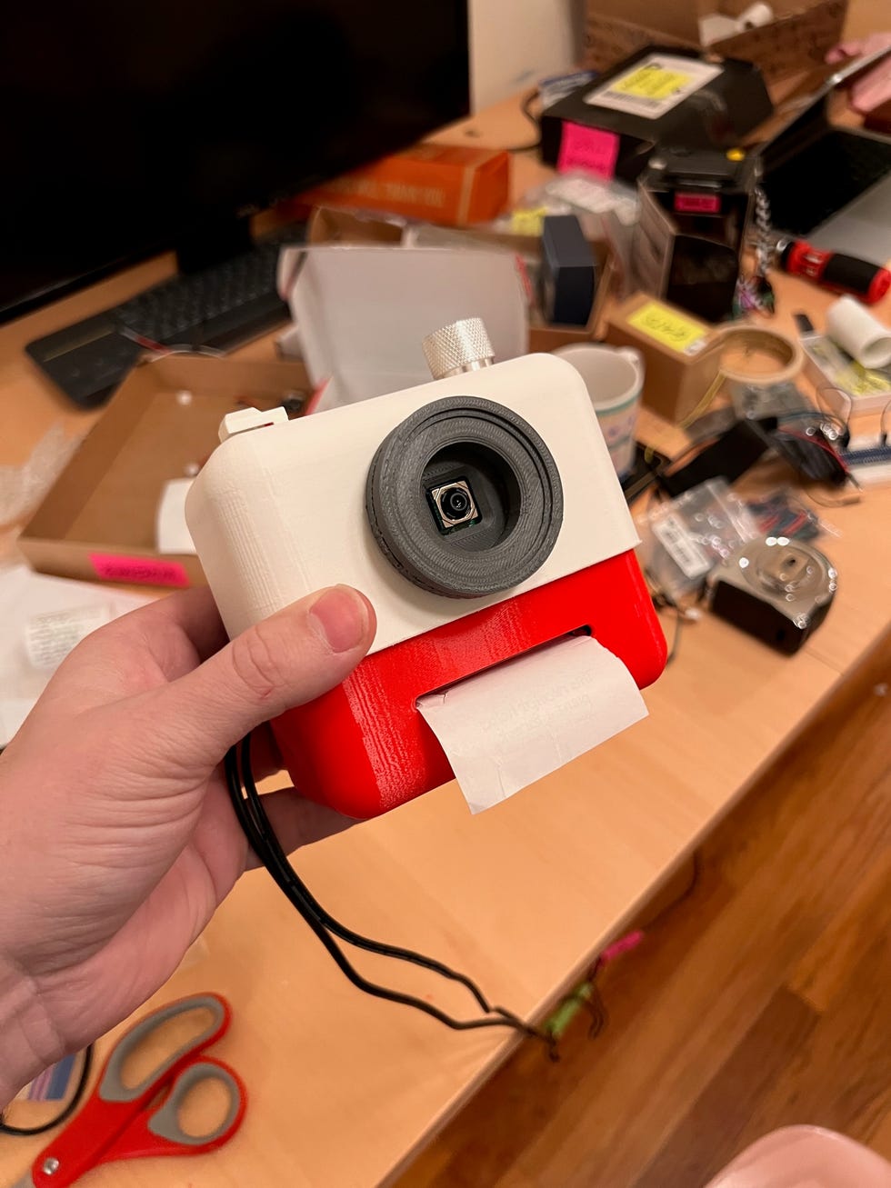 A hand holding a small camera equipped with AI technology