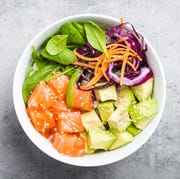 poke bowl with salmon, spinach, avocado, carrot, and red cabbage