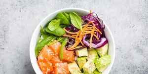 poke bowl with salmon, spinach, avocado, carrot, and red cabbage