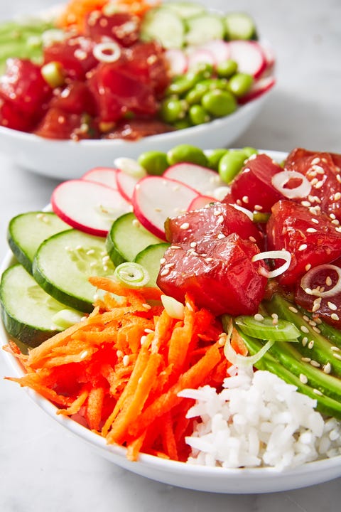 closeup of an ahi tuna white rice bowl with carrots, green onions, cucumbers, radish and edamame