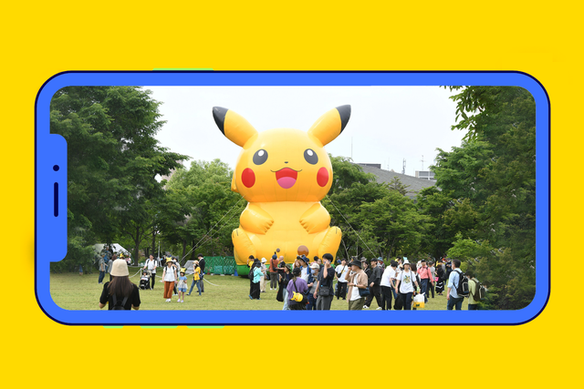 large pikachu balloon at a festival surrounded by a crowd