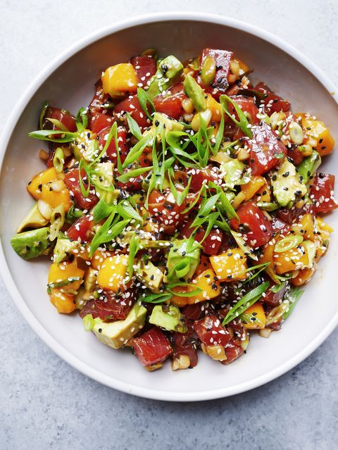 avocado mango poke salad topped with sliced green onions and black and white sesame seeds