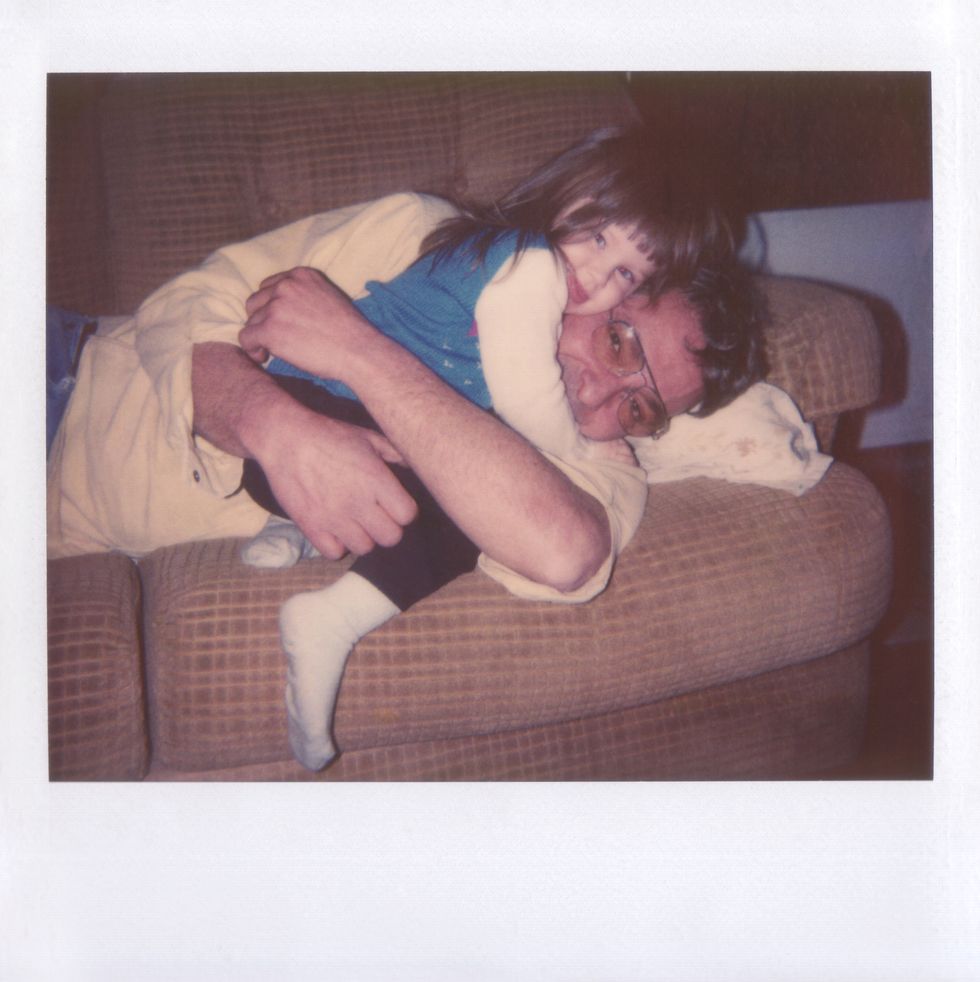 polaroid of father and daughter hugging on couch