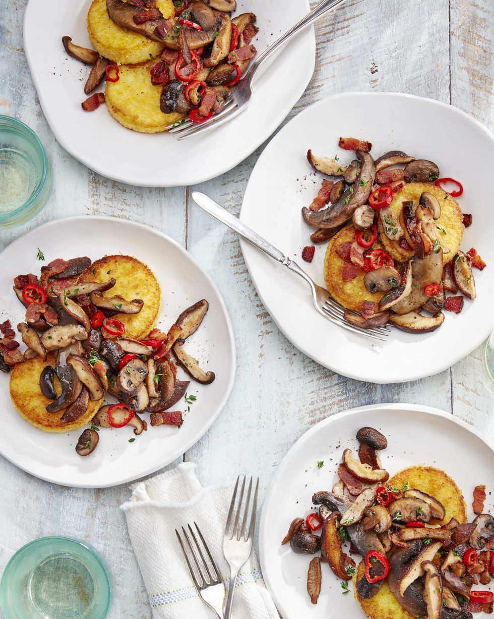 polenta cakes with sauteed mushrooms on white plates with forks