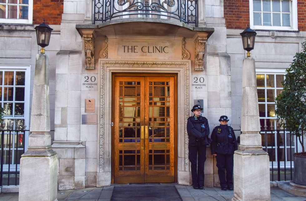 police officers stand outside the private london clinic as