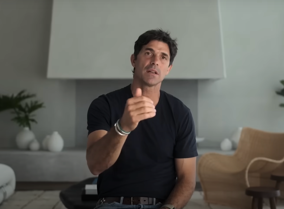 a person gesturing while sitting in a modern living space
