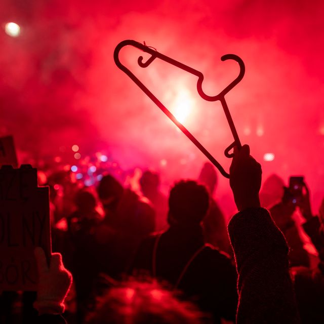a demonstrator holds up a cloth hanger as others light flares during a pro choice demonstration in front of the constitutional court in warsaw, poland, on january 28, 2021, as part of a nationwide wave of protests since october 22, 2020 against polands near total ban on abortion   hundreds of poles rallied in warsaw against a controversial court verdict imposing a near total ban on abortion protesters also took to the streets elsewhere in the eu member in what was the second night of outrage after the constitutional court ruling came into effect on wednesday, january 27, 2021 photo by wojtek radwanski  afp photo by wojtek radwanskiafp via getty images