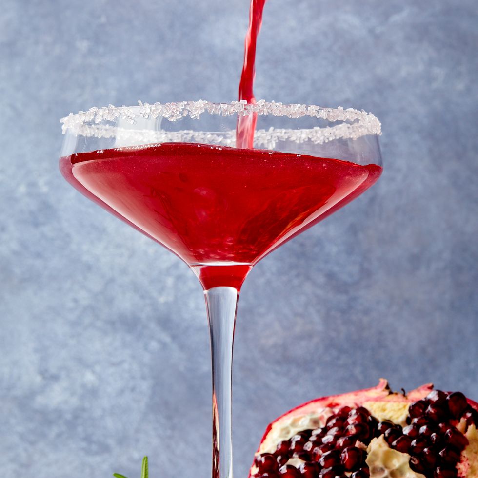 pomegranate martini in a glass with a sanding sugar rim