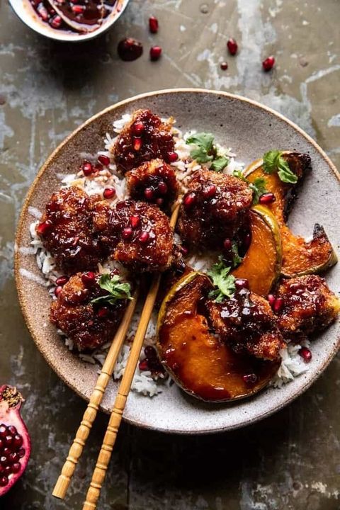 sheet pan sticky pomegranate chicken in bowl with winter squash and chop sticks
