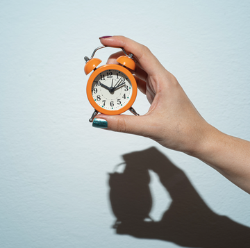 a hand holding a clock