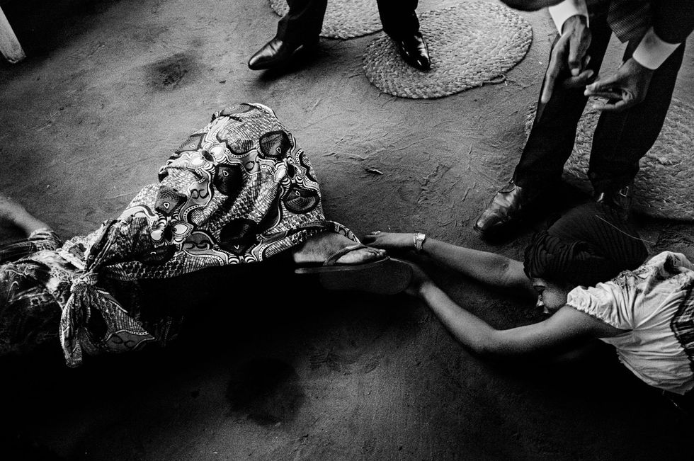 Twee vrouwen liggen op de grond terwijl er een uitdrijving bij hen wordt uitgevoerd tijdens de ochtendcult in glise Peniel Universelles