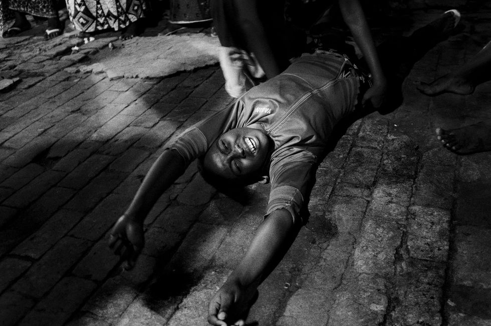 Een vrouw ligt op de grond na een uitdrijving tijdens de avondcult van predikant Mazambi in de commune Kinshasa
