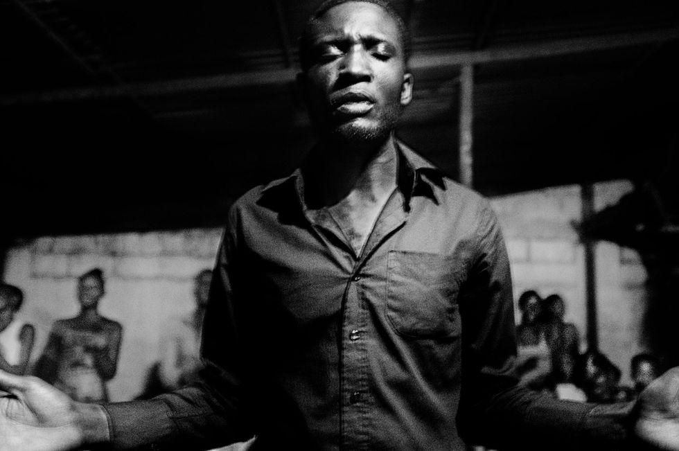 Een man in gebed tijdens de avondcult in de commune Kinshasa