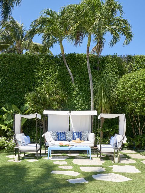 just beyond the pool, gilbane created a shady outdoor living room with a canopied sofa and love seats by century furniture the powder coated coffee table is by mckinnon and harris house beautiful