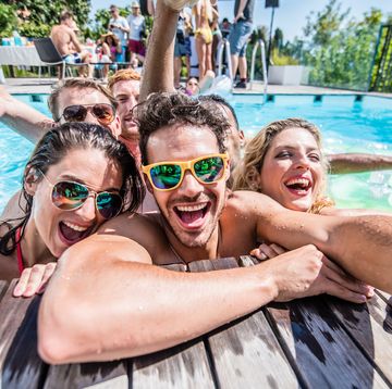 group of young friends taking selfie at pool side during pool party