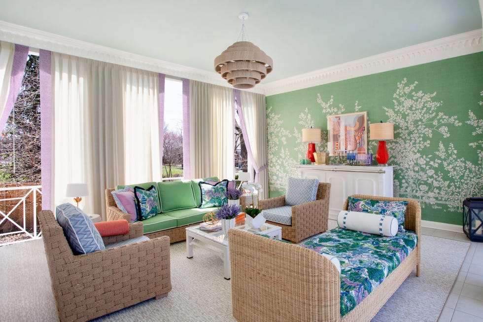 pool house lounge with sofas, chairs, and green tree covered wallpaper