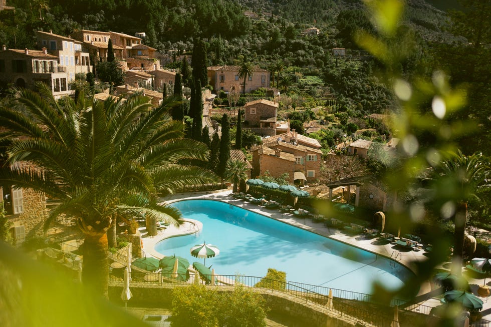serene view of a pool surrounded by lush greenery and historic buildings