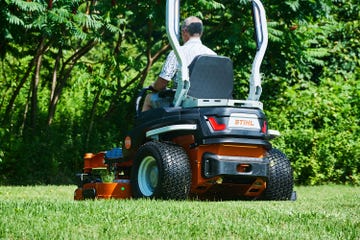 a man in a riding mower cutting the grass