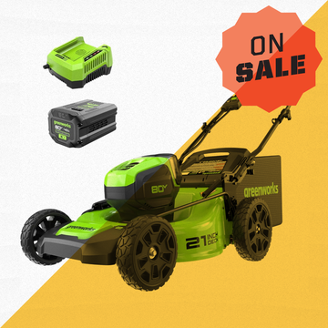 a green and black greenworks lawn mower with a battery and charger