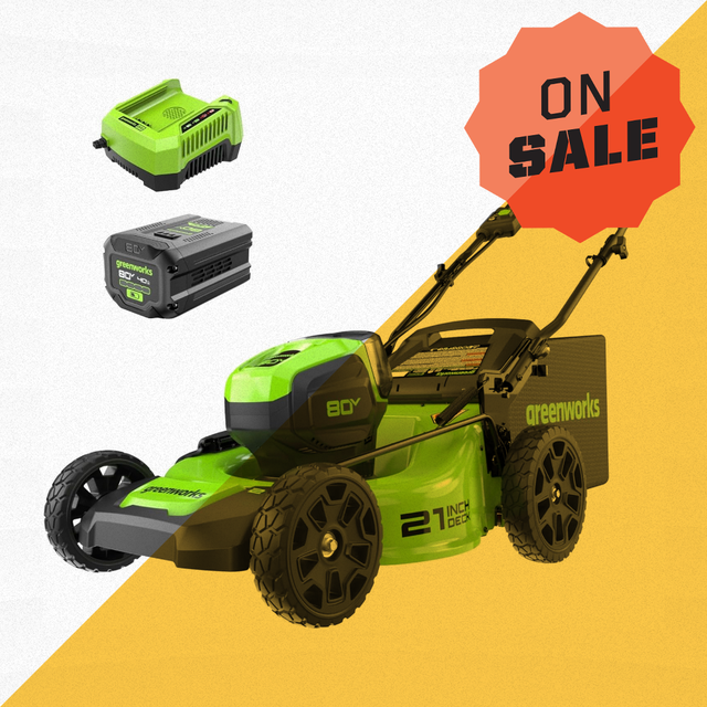 a green and black greenworks lawn mower with a battery and charger