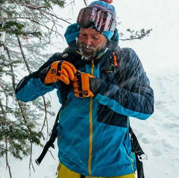 a person in a blue jacket and yellow pants in the snow