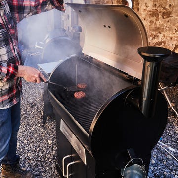 best smokers a person cooking burgers on a smoker grill