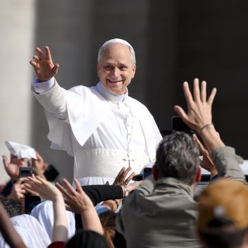 man in religious garments waving to a crowd and smiling