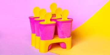homemade popsicles, ice cream sticks on bright pink yellow colors background