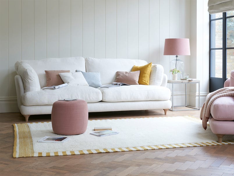 salón con sofá blanco y butaca rosa