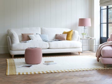 salón con sofá blanco y butaca rosa