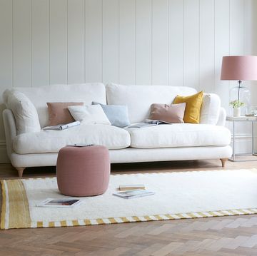 salón con sofá blanco y butaca rosa