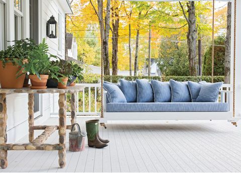 white porch with swing bench and pots