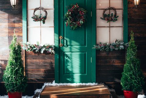 porch with wooden doors and a threshold with christmas decor