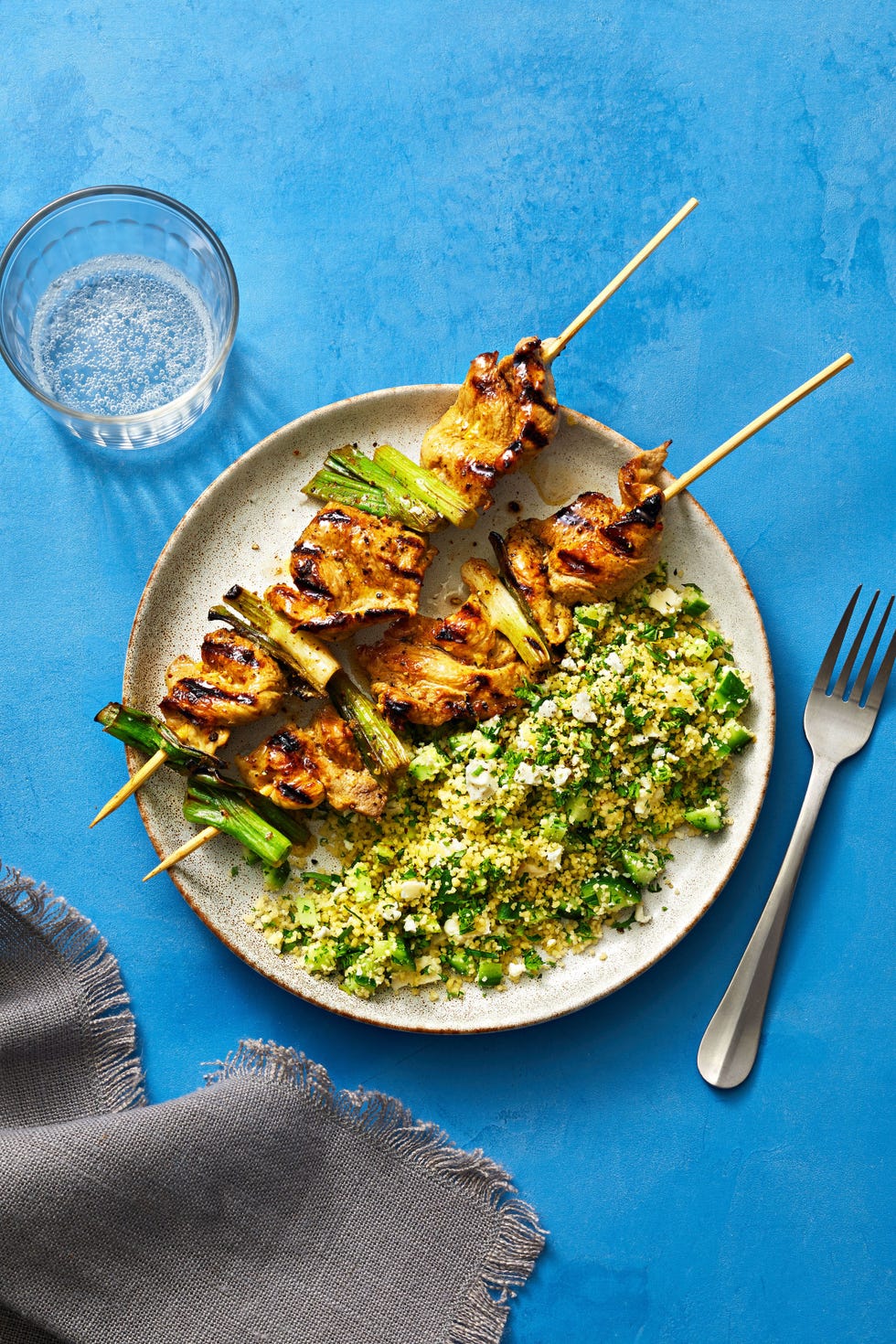 pork and scallion kebabs with herbed couscous on a plate