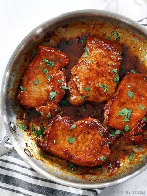 glazed pork chops in pan with herbs