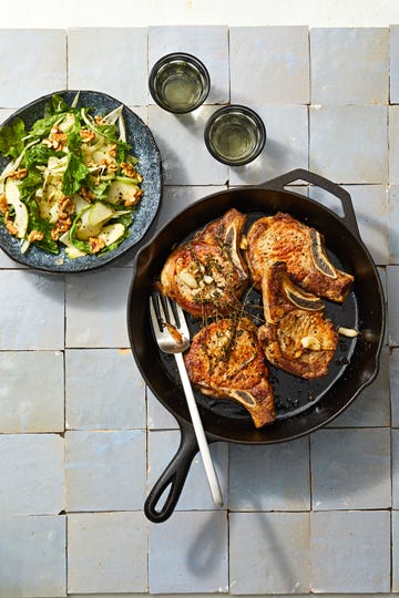 pork chops and pear salad on a tile background